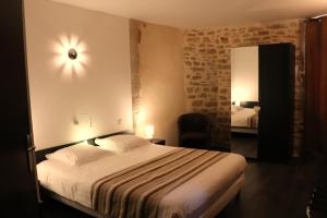 Habitación de hotel con cama y espejo en Hôtel Restaurant LE SAINT AUGUSTIN, en Saint-Amour