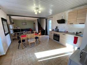 eine Küche und ein Wohnzimmer mit einem Tisch und Stühlen in der Unterkunft Maison indiv au cœur du vignoble champenois in Lignol-le-Château