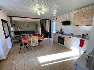 kuchnia i salon ze stołem i krzesłami w obiekcie Maison indiv au cœur du vignoble champenois w mieście Lignol-le-Château