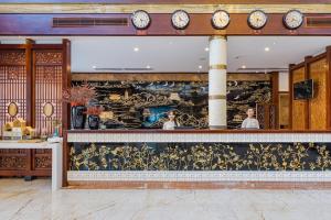 um restaurante com um balcão com relógios na parede em S&N Hotel Sanqingshan em Shangrao