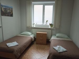 two beds in a room with a window at Hotel Kardinal in Vinnytsya