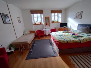a bedroom with two beds and a couch and a table at Penzión Evka in Poprad