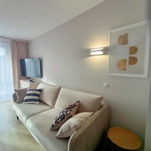 a living room with a couch and a tv at Apartament Emili VIPOO in Suwałki