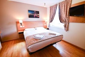 a hotel room with a bed and a window at Kings Cross Inn Hotel in London