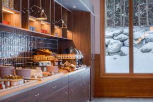 a kitchen with a counter with plates and food at Big Sky Hotel in Chamonix-Mont-Blanc