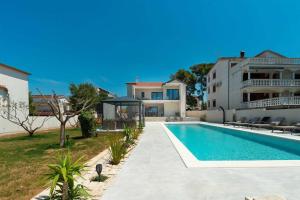 a villa with a swimming pool and a house at Luxury villa Magale with large pool in Biograd na Moru