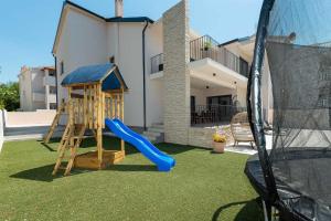 a playground with a slide and a play structure at Luxury villa Magale with large pool in Biograd na Moru