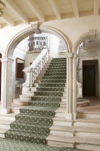 un escalier dans un bâtiment avec colonnes dans l'établissement Hotel Palazzo Novello, à Montichiari