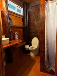 a small bathroom with a toilet and a sink at The Diving Lodge Downtown in Puerto Morelos