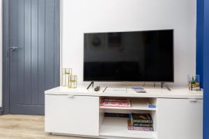 a white entertainment center with a flat screen tv at Methuen Mews - 2 double bedroom townhouse within walking distance to beach, on-street parking in Portsmouth in Portsmouth