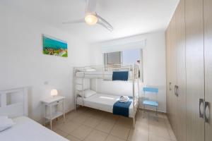 een kleine kamer met een stapelbed en een stoel bij Protaras Sapphire Seaside Villa in Protaras +91 foto's