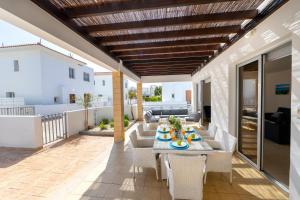 een terras met een tafel en stoelen op een balkon bij Protaras Sapphire Seaside Villa in Protaras