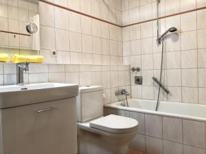 een badkamer met een toilet, een wastafel en een bad bij Ferienwohnung Jessen in Oberstaufen