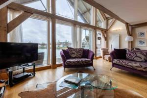 a living room with couches and a tv and a glass table at Otters Holt in Somerford Keynes
