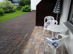 a patio with two chairs and a white table and chairs at Ferienwohnung Mack in Oberstaufen