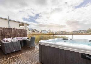 a hot tub on a deck with a table and chairs at Otters Holt in Somerford Keynes
