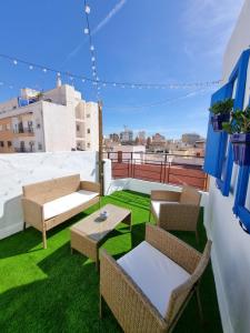 eine Terrasse mit Stühlen und Tischen auf dem Dach in der Unterkunft Terraza Almería in Almería