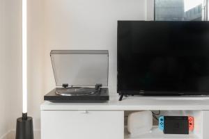 a flat screen tv sitting on top of a white table at Martini Manor in Capel Sound