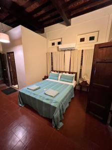 a bedroom with a bed with blue pillows at Raasa Veedu in Settūr +26 photos