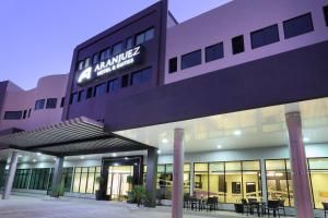 a purple building with tables and chairs in front of it at Aranjuez Hotel & Suites in David