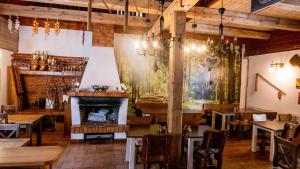 um restaurante com lareira e mesas e cadeiras de madeira em Penzion Pod Houskou em Blatce