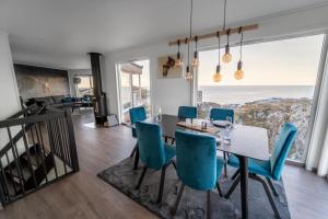 a dining room with a table and blue chairs at Runde Panorama - Ørneredet in Runde