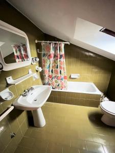 a bathroom with a sink and a bath tub at Nunzia - Trilocale con terrazzo vista mare e doppi servizi in Sirolo
