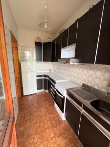 a kitchen with black cabinets and white appliances at Nunzia - Trilocale con terrazzo vista mare e doppi servizi in Sirolo