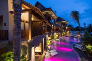 a villa with a swimming pool at night at Sense Canggu Beach Hotel in Canggu