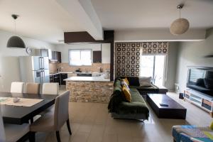 a living room with a couch and a table and a kitchen at Glabur Stays - The Executive 2 BDR - Nicosia City, Free Parking & Wifi, Welcomes You!!! in Nicosia