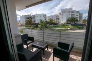 balcón con sillas y mesa y vistas a los edificios en Glabur Stays - The Executive 2 BDR - Nicosia City, Free Parking & Wifi, Welcomes You!!!, en Nicosia