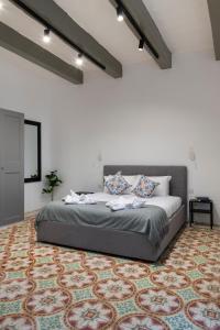 a bedroom with a large bed with a rug at Valletta Collection - Felix Apartments in Valletta