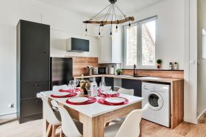 een keuken met een witte tafel en stoelen en een keuken met een vaatwasser bij Appartement Le Chaleureux Chalon - Hyper-Centre in Chalon-sur-Saône