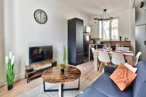 een woonkamer met een blauwe bank en een tafel bij Appartement Le Chaleureux Chalon - Hyper-Centre in Chalon-sur-Saône