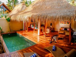 a room with a swimming pool and a hut at Pera ONE Villas in Gili Trawangan