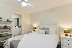 a white bedroom with a bed and a ceiling fan at Avenue Family Retreat in Rosebud