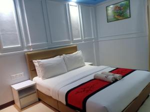 una habitación de hotel con una cama con un animal de peluche. en Motel Fyna en Kangar
