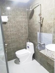 uma casa de banho com um WC, um chuveiro e um lavatório. em Khách sạn Gia Nghiêm em Ấp Trà Kha