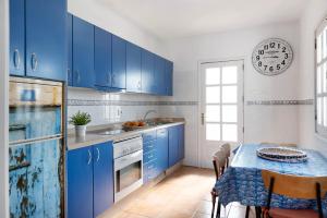 una cocina azul con una mesa y un reloj en la pared en El Charco Azul en Charco del Palo