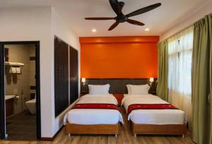 a bedroom with two beds and a ceiling fan at Kokol Haven Resort in Kota Kinabalu