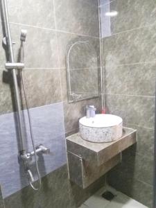 bagno con lavandino e doccia di Khách sạn Gia Nghiêm a Ấp Trà Kha