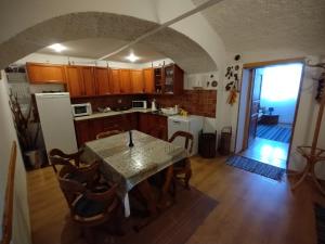 a kitchen with a table and a dining room with a door at Penzión Evka in Poprad
