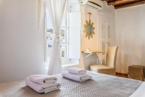 a room with towels on a table with a window at Seablue Town Maisonette Mykonos in Mýkonos City