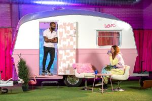 a man standing in the door of a pink and white caravan at Outside Inn in Amsterdam