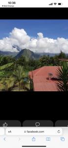 a television screen with a view of a house with a roof at Location saisonniere villa l arosatier in Hell-Bourg