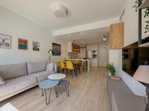 a living room with a couch and tables and a kitchen at Bianca Beach 222 - Mil Palmeras, vista piscina y mar in La Horadada