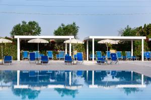ミネルヴィーノ・ディ・レッチェにあるDolmen Sport Resortのプールサイドの椅子とパラソルのグループ