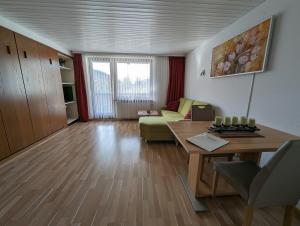 uma sala de estar com uma mesa e um sofá em B5 Albmatte-FEWO Sauna, Hallenbad Außenbecken Massagen nebenan em Menzenschwand-Hinterdorf