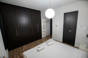 1 dormitorio con armarios negros y 1 cama blanca en Glabur Stays - The Amazing 2 BDR - Nicosia City, Free Parking & WiFi, en Nicosia
