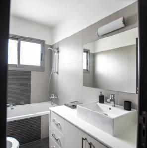 y baño blanco con lavabo y bañera. en Glabur Stays - The Amazing 2 BDR - Nicosia City, Free Parking & WiFi en Nicosia